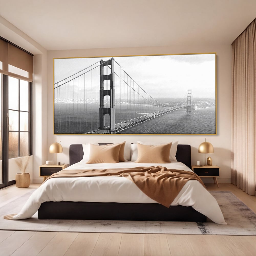 Tablou canvas cu fotografie alb-negru cu podul golden gate, in rama de aluminiu auriu, pe perete intr-un dormitor